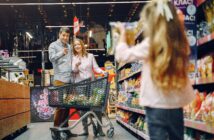 A parent checking a food label while shopping with a child